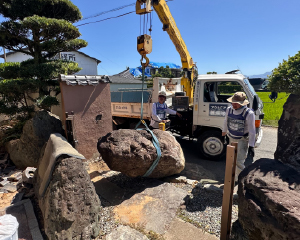 Removing a large fallen boulder using a crane.