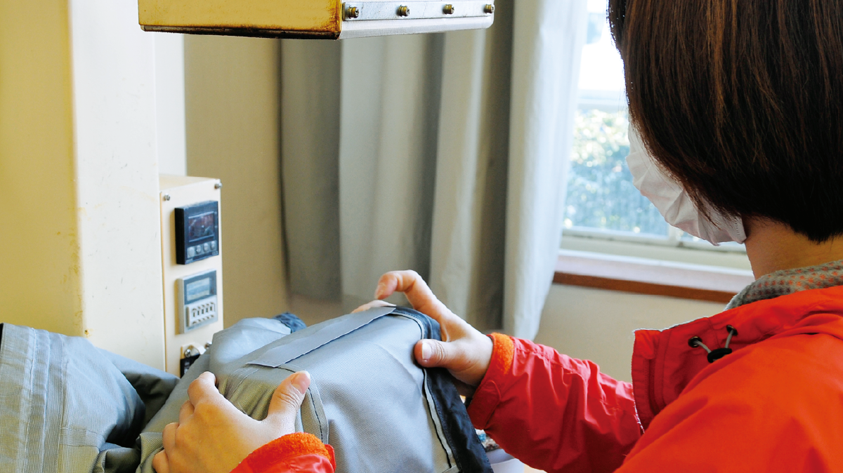 Applying seam tape to waterproof breathable fabric using specialized machinery.