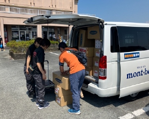 Unloading relief supplies from a vehicle and handing them out.