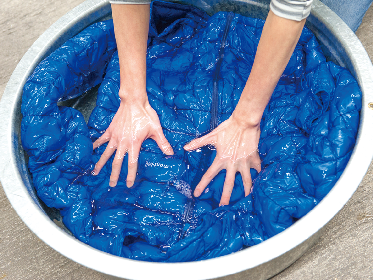 Hand-washing down outerwear by pressing it in a bucket