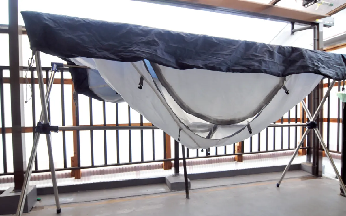 The tent is spread out and hung on a clothesline to dry.