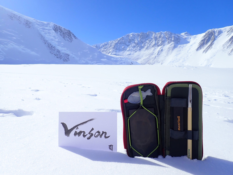 A calligraphy set leaning against the snow surface with a work inscribed "Vinson"