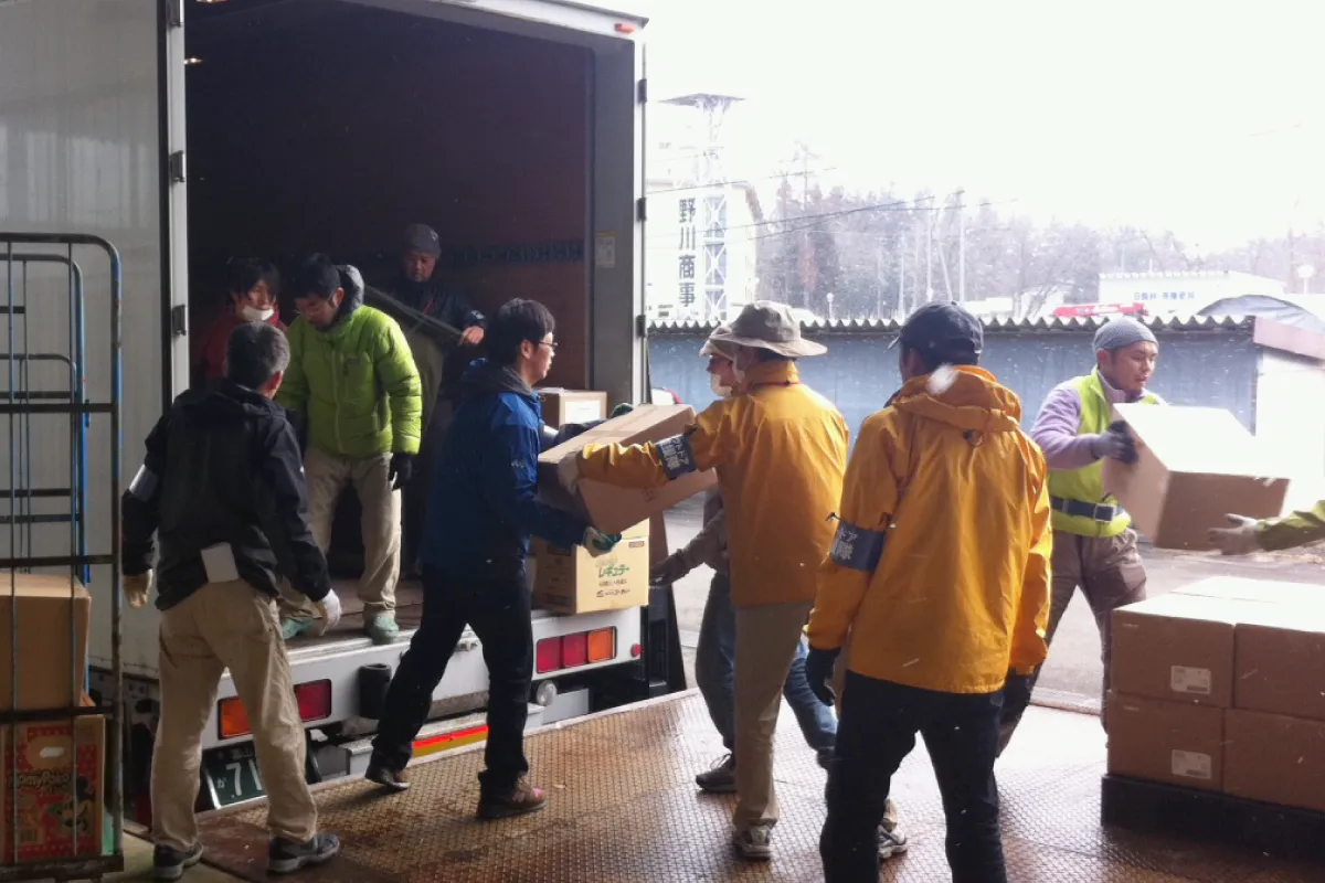 Several Outdoor Gientai staff members loading relief supplies onto a truck.