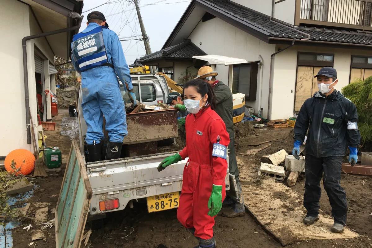 Four Outdoor Gientai staff members loading debris onto a truck.