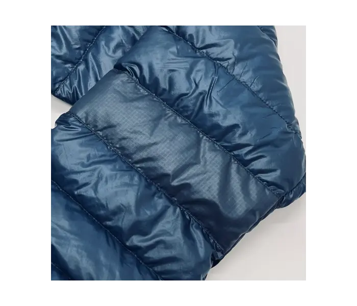 Down jacket after repair: with a slightly different covering than the original fabric to match the size of the quilt.