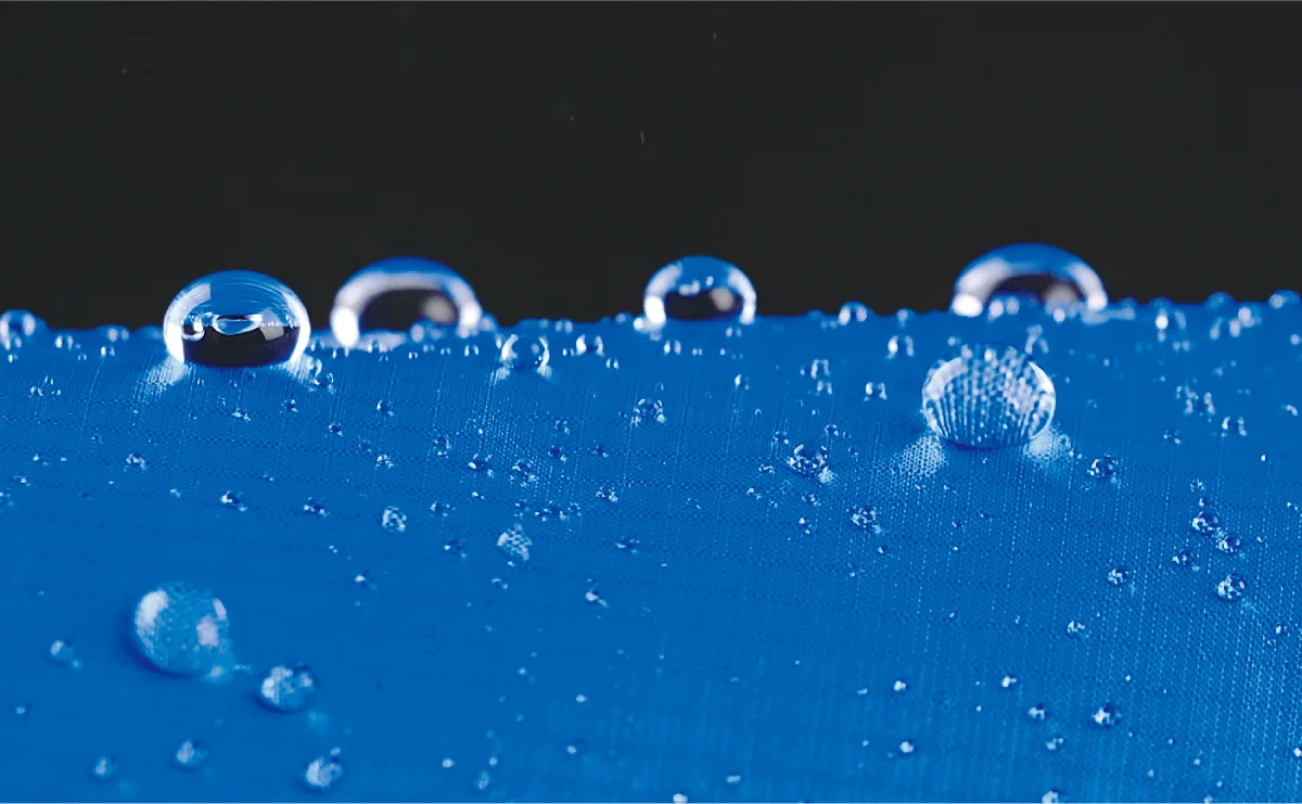 The fabric is strongly water-repellent, with many water droplets sitting on it.