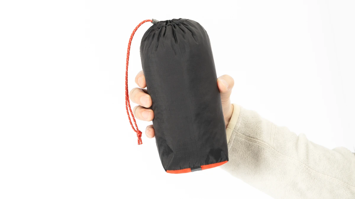 Photo of holding the garment packed in its stuff sack.