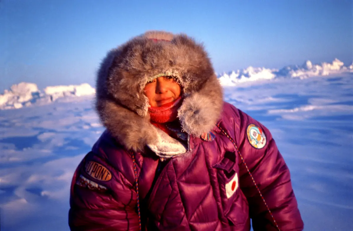 Masako Izumi wearing a purple down coat and fur hat upon successful arrival at the North Pole.