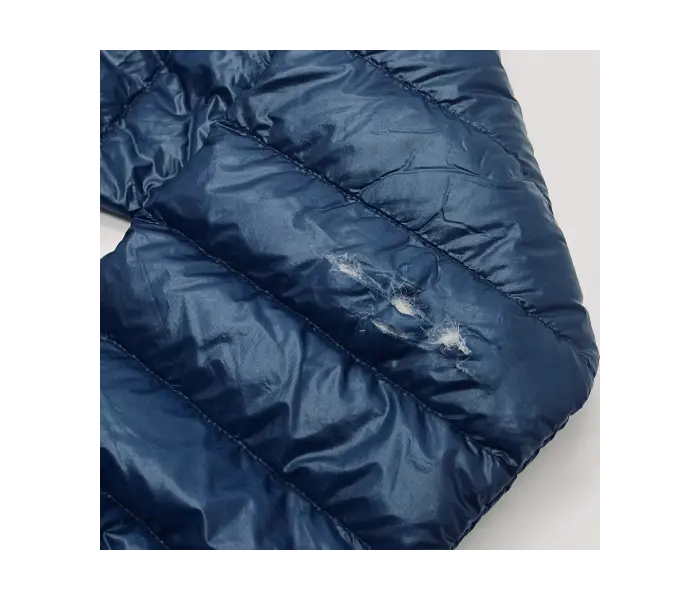 Down jacket before repair: tear in one quilt.