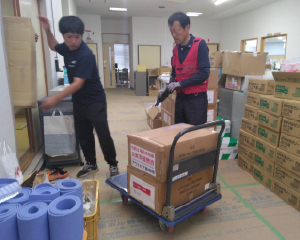 Transporting relief supplies on a hand truck.
