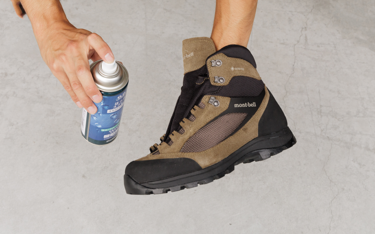 A scene of applying water-repellent spray to the dried hiking boots.