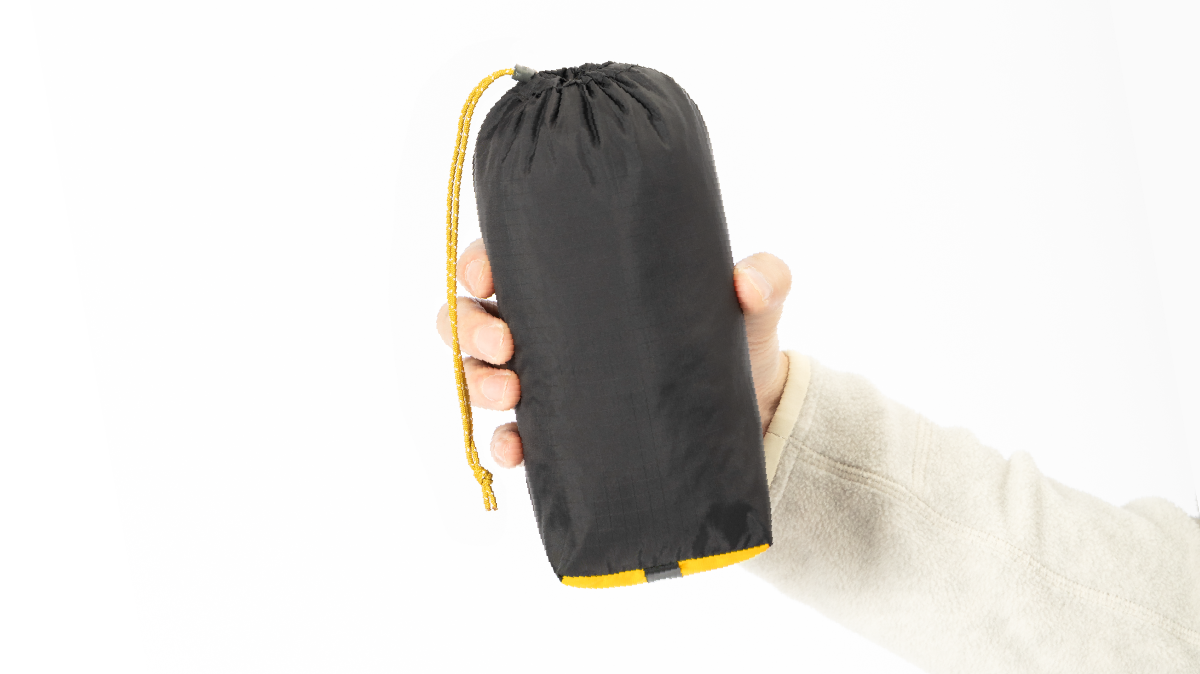 Photo of holding the garment packed in its stuff sack.