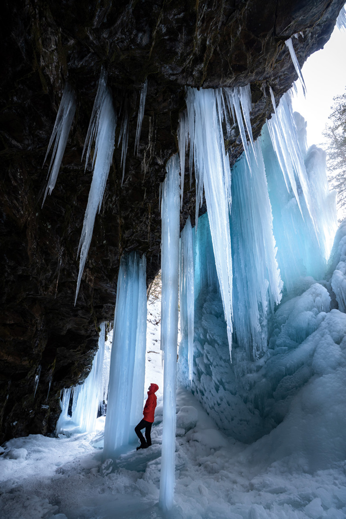 A mountaineer looking up at countless icicles