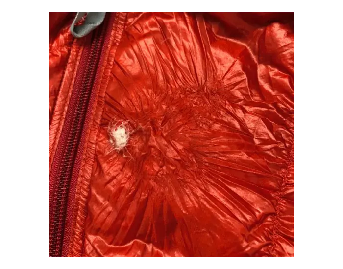 Sleeping bag before repair: Small holes in the fabric.